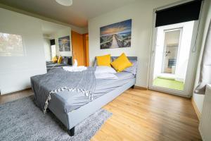 a bedroom with a bed with yellow pillows at FULL HOUSE Premium Apartments - Zwickau rooftop in Zwickau