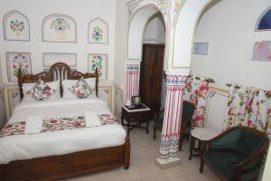 a bedroom with a bed and a chair at KothiPushkar in Pushkar