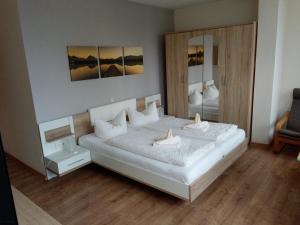 於克里茨的住宿－Hotel Ratscafe Ückeritz，卧室配有一张白色大床和镜子
