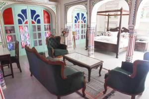 a living room with chairs and a bed and a table at KothiPushkar in Pushkar