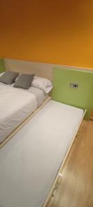 a couple of beds in a small room with at Piso Estación Termal II in Ourense
