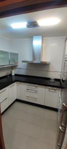 a kitchen with white cabinets and black counter tops at Piso Estación Termal II in Ourense