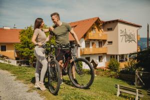 a man and a woman standing next to their bikes at Der Almblick in Strallegg