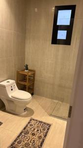 a bathroom with a toilet and a window at شقة فاخرة تحتوي على غرفتي نوم و مدخل خاص جانبي in Riyadh