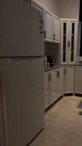 a kitchen with white cabinets and a refrigerator at شقة فاخرة تحتوي على غرفتي نوم و مدخل خاص جانبي in Riyadh
