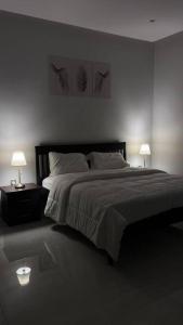شقة فاخرة تحتوي على غرفتي نوم و مدخل خاص جانبي في الرياض: غرفة نوم بسرير كبير فيها مصباحين