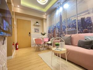 een woonkamer met een roze bank en een tafel bij SMDC Trees Residences Tower 1 - 2BR Newly Renovated Staycation in Manilla