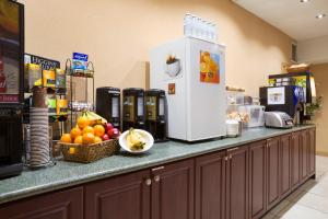 a counter with a refrigerator and a bowl of fruit at Days Inn by Wyndham Woodstock in Woodstock