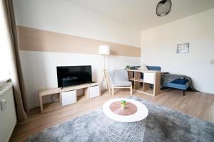 a living room with a television and a living room with a table at FULL HOUSE Studios - R85 Apartments in Zwickau