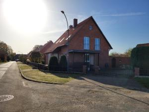 una casa de ladrillo rojo al lado de una calle en Ferienwohnung Ruheoase Lüneburger Heide, en Natendorf