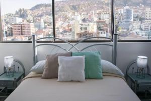 a bed in a room with a view of a city at Sky Suites - Fantastic Apt in the heart of La Paz in La Paz