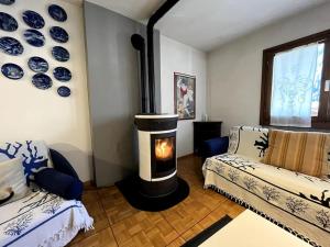 a living room with a wood burning stove in a room at Pinzolo Centro - Baita Spaziosa con Vista sui Monti in Giustino