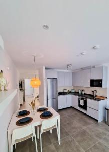 a kitchen with white cabinets and a table and chairs at Brand New - Massive Studio - E1 - Self Catering in Gibraltar