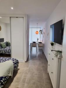 a bedroom with a bed and a tv and a table at Brand New - Massive Studio - E1 - Self Catering in Gibraltar