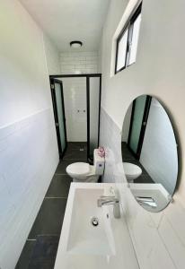 a bathroom with two sinks and a mirror and two toilets at Zoola San Pedro Atitlan in San Pedro La Laguna