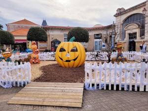 a halloween pumpkin sitting on the ground next to white chairs at Appartement 4 pers au coeur de Soulac-sur-mer in Soulac-sur-Mer