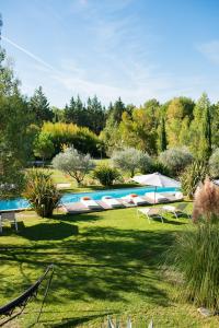 una piscina en un jardín con árboles en el fondo en Maison Jalon, en Aix-en-Provence