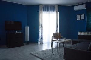 a blue living room with a couch and a tv at Apartmani Tika in Golubac