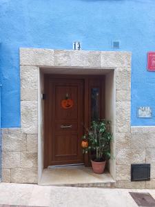 un edificio azul con una puerta con una calabaza. en La Casassa II, en Les Coves de Vinroma