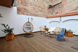 un patio con sillas, una mesa y una pared de ladrillo en Althof Apartments en Sibiu