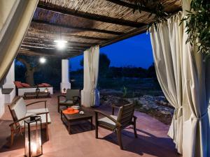 a patio with chairs and a table with a view at I Mulicchi in Specchia