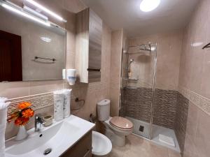 a bathroom with a shower and a toilet and a sink at Estudios Costavigía Mazagón by Ramona in Mazagón