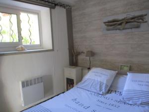 um quarto com uma cama com lençóis brancos e uma janela em Face au Cap 1 em Cassis