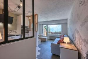 a living room with a couch and a kitchen at IMMOBILIER DE MONTAGNE - La Collection - The View in Saint-Gervais-les-Bains