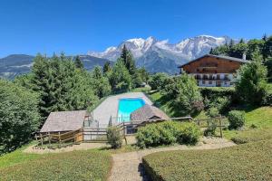 a house with a swimming pool on a hill with mountains at IMMOBILIER DE MONTAGNE - La Collection - The View in Saint-Gervais-les-Bains