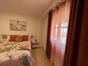 a bedroom with a bed and a window at Estudios Costavigía Mazagón by Ramona in Mazagón