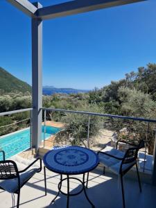een balkon met een tafel en stoelen en een zwembad bij Villa Maya Lefkada in Évyiros