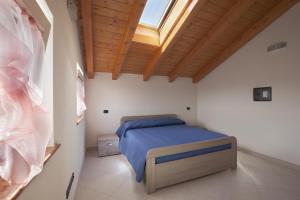 a bedroom with a bed in a room with a window at Appartamenti al Canton in Colà di Lazise