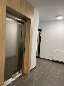 einen Aufzug in einem Bürogebäude mit einer Metalltür in der Unterkunft Apartament Park Poezji in Gliwice