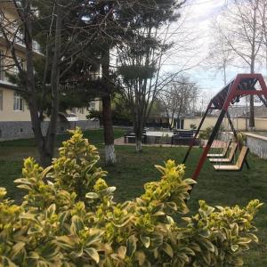 a playground with a swing set in a park at Gabala Hotel in Daşca