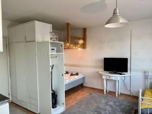 a living room with a television and a white refrigerator at Apartment Kopin in Kokkola