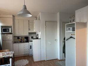 a kitchen with white cabinets and a white refrigerator at Apartment Kopin in Kokkola +3 photos