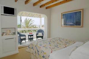 a bedroom with a bed and a large window at miKasa Agua Amarga & SPA in Agua Amarga