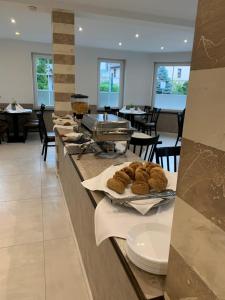 a restaurant with a counter with pastries on it at Hotel Langhans in Abstatt