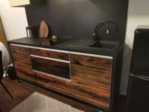 uma cozinha com um lavatório e uma cómoda em madeira em Apartamenty Motyl em Bytom