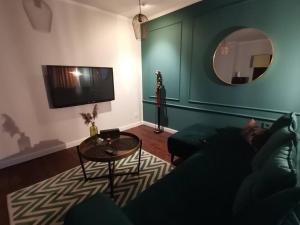 uma sala de estar com um sofá, uma mesa e um espelho em Apartamenty Motyl em Bytom