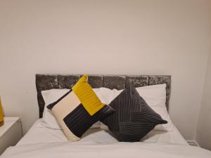 a bed with black and yellow pillows on it at TimeChance Property Homz - Norton Road 1 Bed Apartment in Stockton-on-Tees