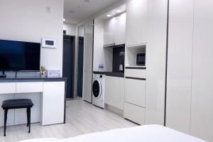 uma cozinha branca com máquina de lavar e secar roupa em Central City em Incheon