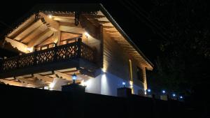a house with a balcony lit up at night at Chalet Bakuriani in Bakuriani