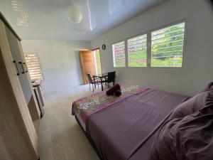 Bora Bora Fare Sophia في بورا بورا: غرفة نوم بسرير وطاولة وكراسي