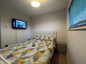 a bedroom with a bed with a tv on the wall at Chalet 59 Florida Holiday Park Hemsby in Hemsby