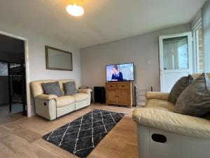 a living room with two couches and a flat screen tv at Chalet 59 Florida Holiday Park Hemsby in Hemsby