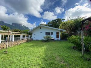 a small white house with a grass yard at Bora Bora Fare Sophia in Bora Bora