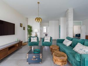 uma sala de estar com um sofá verde e uma televisão de ecrã plano em MCD Sea Sunset Deluxe em Las Palmas de Gran Canaria