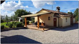 ein kleines Haus mit einem Dach auf einer Kieseinfahrt in der Unterkunft Holiday home in Cortona/Toskana 30389 in Cortona