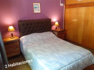 a bedroom with a bed and two night stands with lamps at Cabañas Don Pocho in Villa Cura Brochero +42 photos